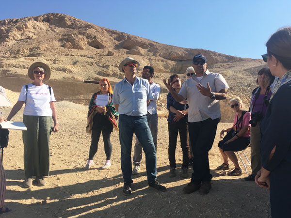 Bill Manley and Amr El Sharqawy talk to BSS students in front of the tomb of Ankhtify at Mo’alla