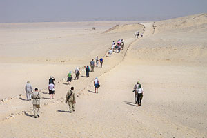 Group walking desert path to Amarna South Tombs.